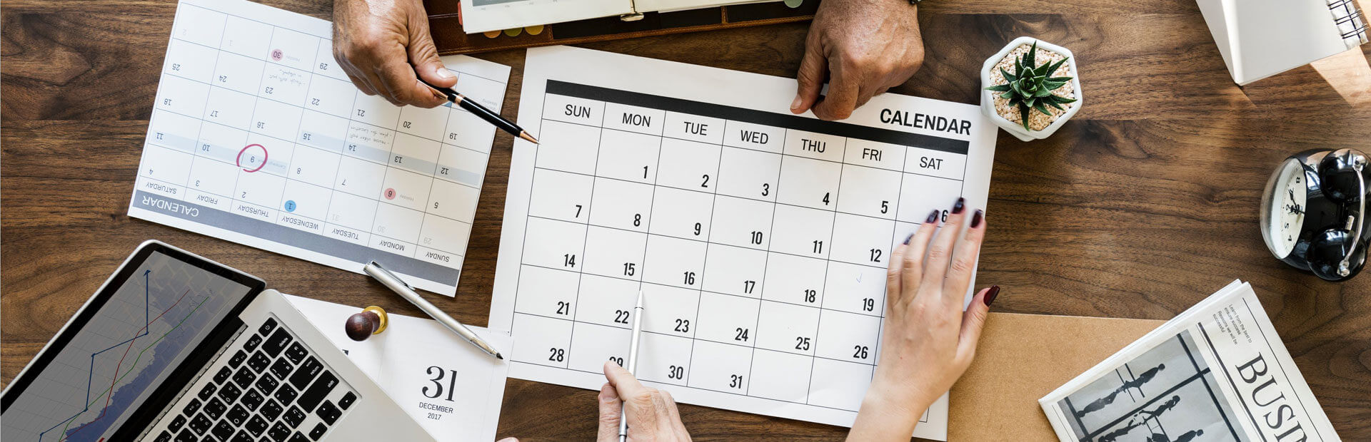 Een team van individuen die samenwerken aan een contentkalender op een bureau.